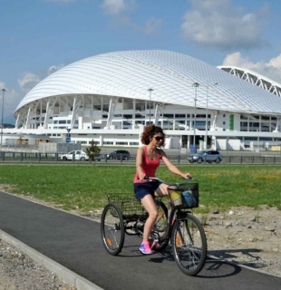 девушка едет на велосипеде вокруг стадиона фишт