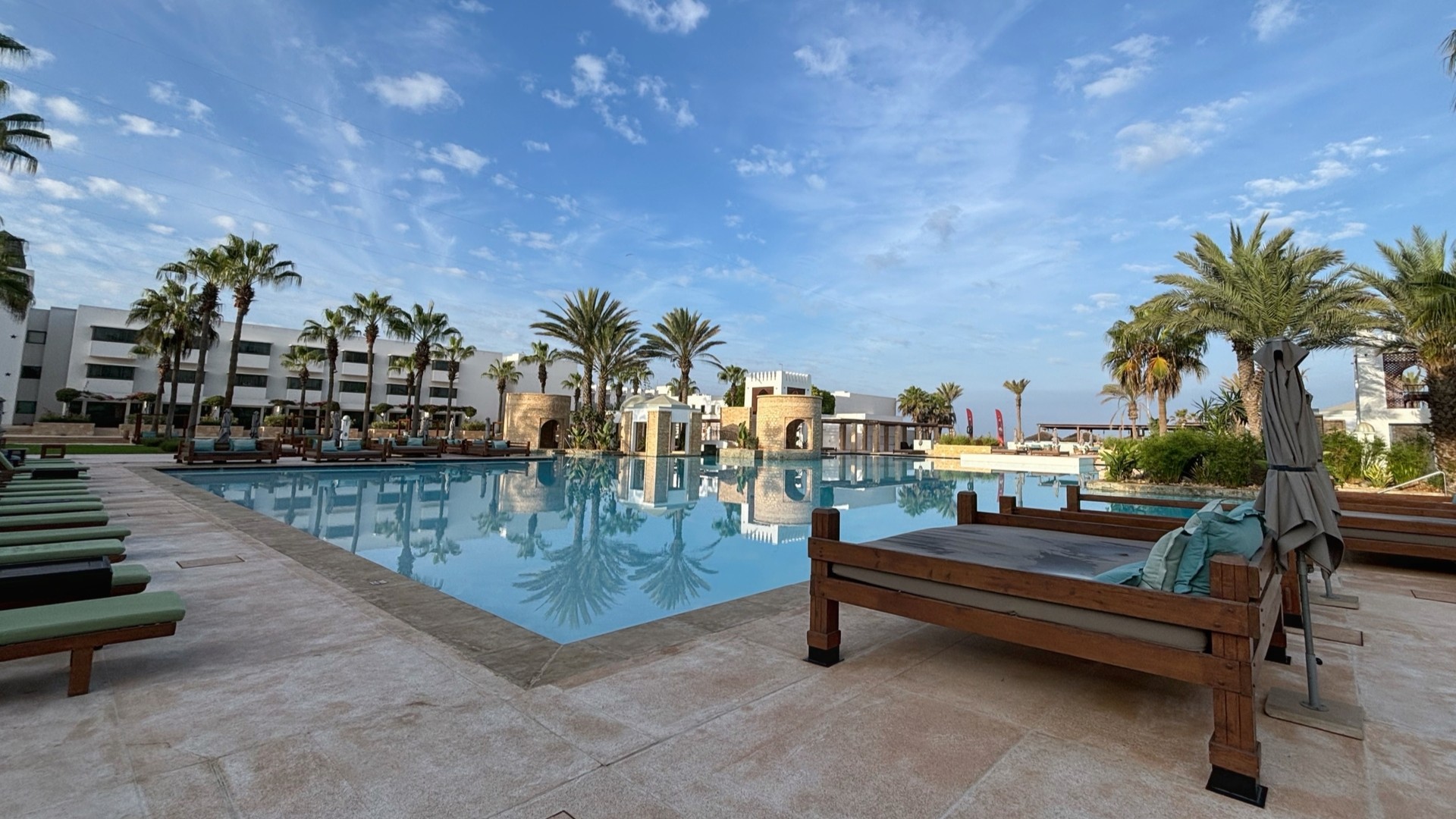 Вид на бассейн отеля Sofitel с пальмами и шезлонгами, Агадир.
